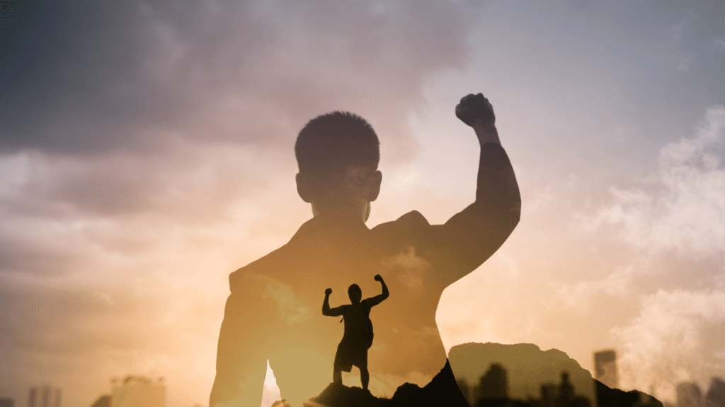 Person standing atop a mountain, raising their hands in triumph to celebrate their success